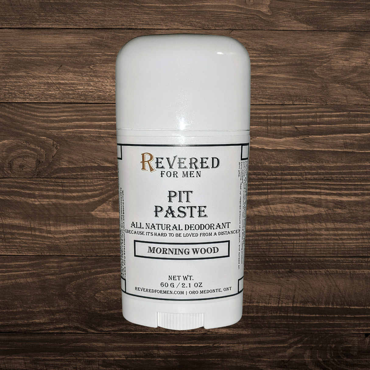 White deodorant stick with 'Revered for Men' branding on a wooden background